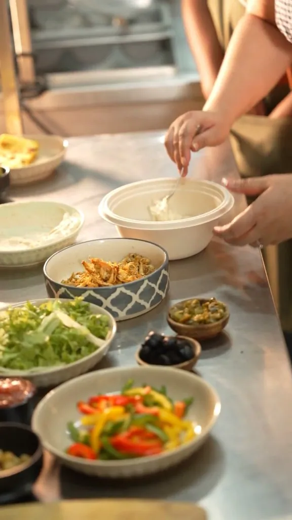 Hands working over fresh ingredients on the marble prep counter at Clean & Green
